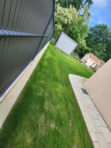 Pelouse fraîchement tondue le long d’une clôture